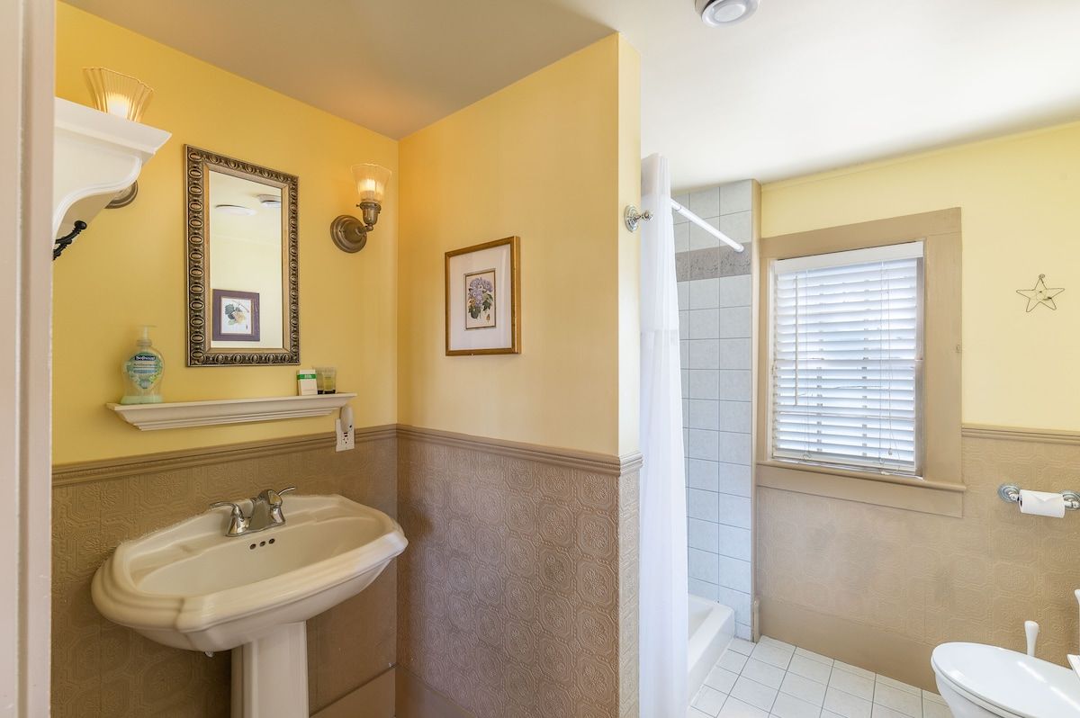 A clean and well-maintained bathroom with a sink, mirror, and shower.