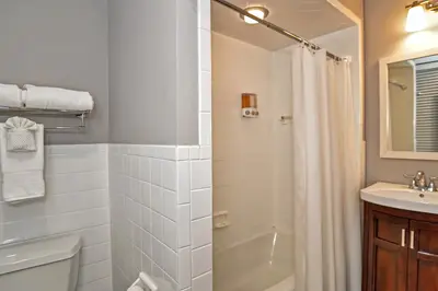 A clean and modern bathroom with a bathtub, shower, and vanity.
