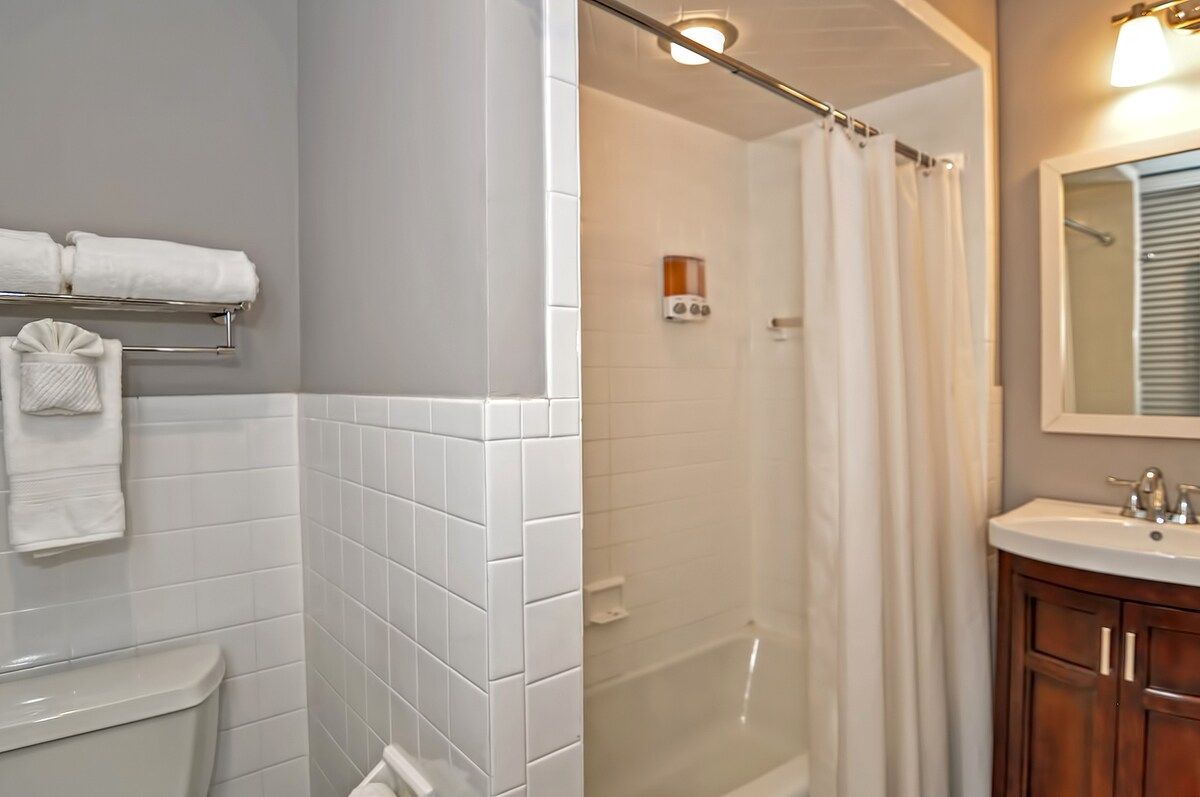 A clean and modern bathroom with a bathtub, shower, and vanity.