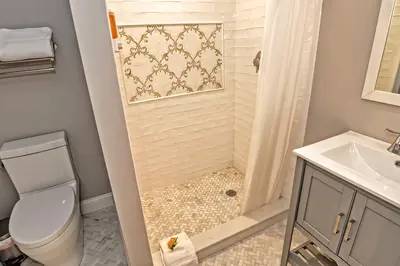 A clean and modern bathroom with a white toilet, shower, and vanity.