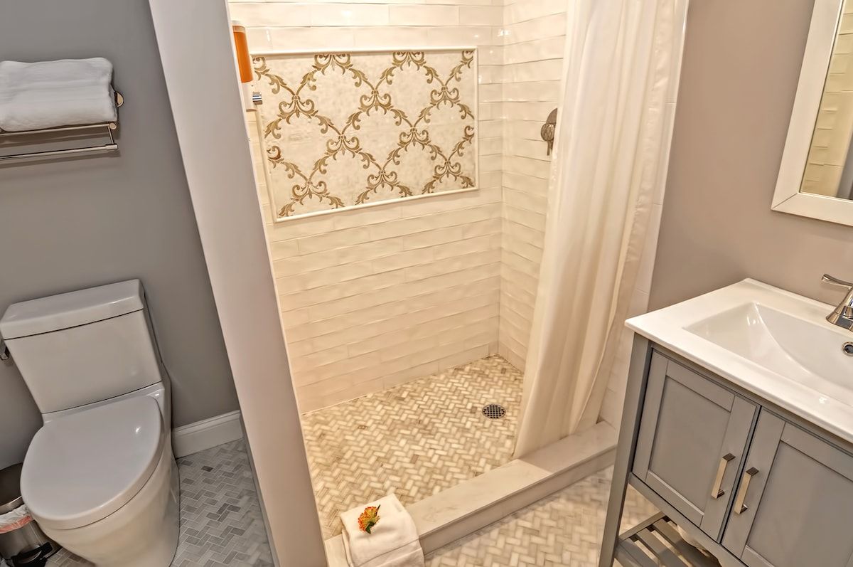 A clean and modern bathroom with a white toilet, shower, and vanity.