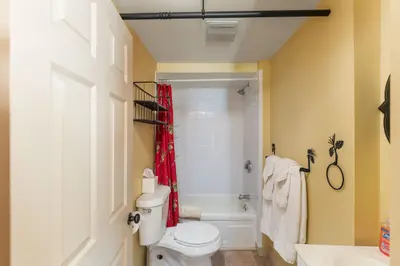 A clean and well-maintained bathroom with a white bathtub, toilet, and sink.