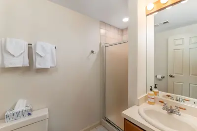 A clean and well-maintained bathroom with a sink, mirror, and shower.