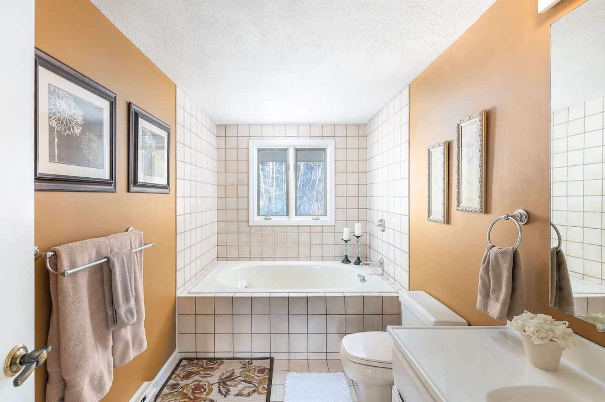 A clean and well-appointed bathroom with a white bathtub, toilet, and sink.