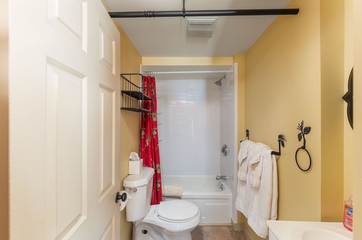 A clean and well-maintained bathroom with a white bathtub, toilet, and sink.