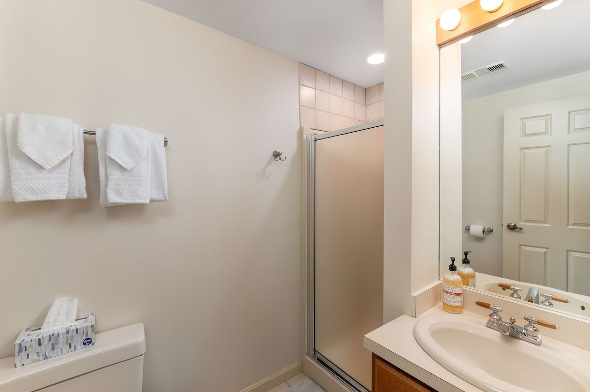 A clean and well-maintained bathroom with a sink, mirror, and shower.