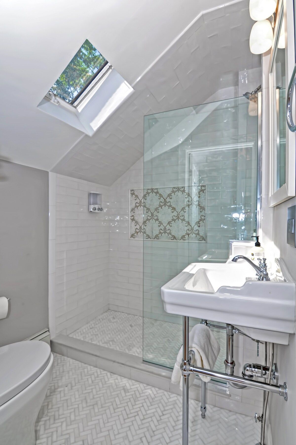 A clean and modern bathroom with a white sink, toilet, and shower.