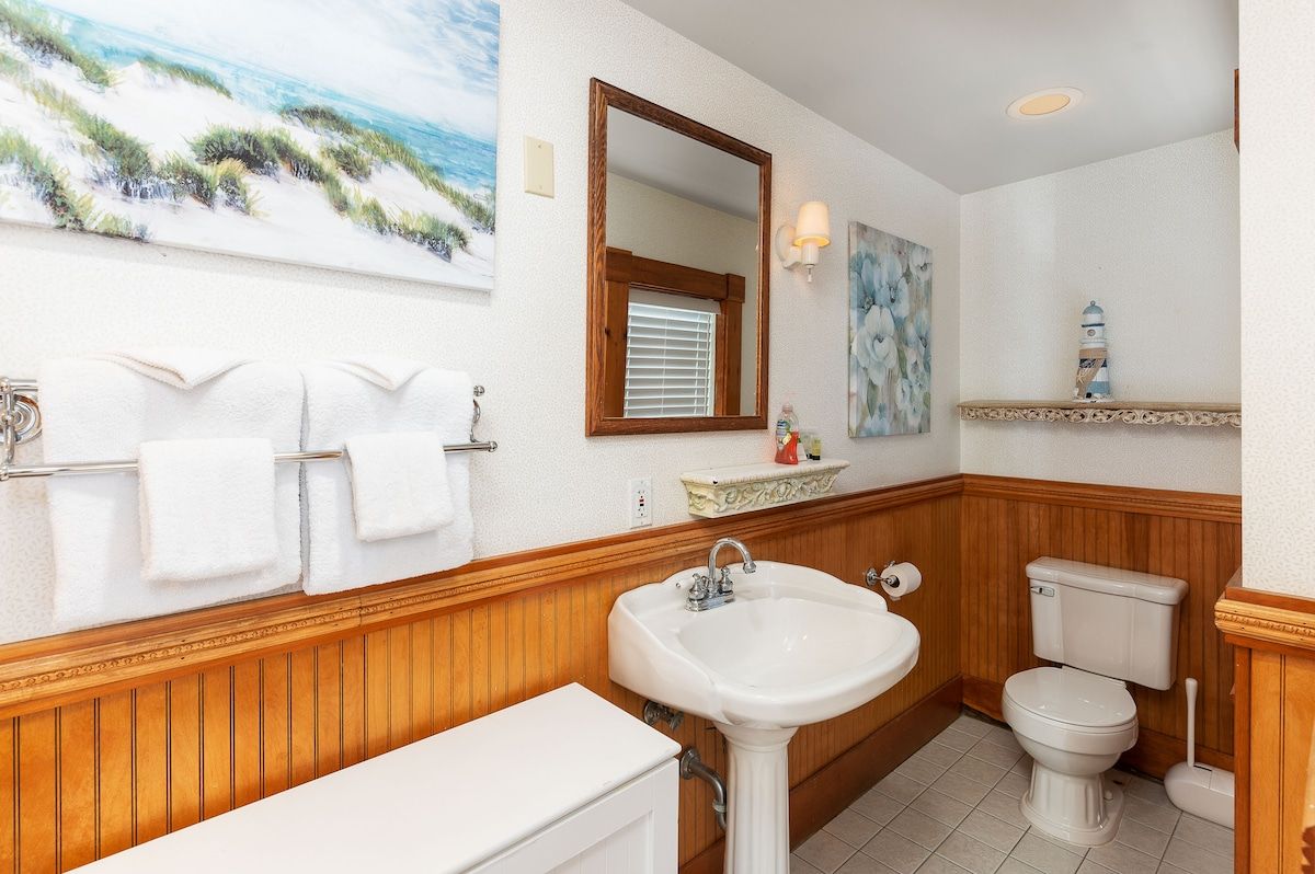 A clean and well-maintained bathroom with a white sink, toilet, and bathtub.