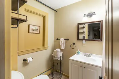 A clean and well-appointed bathroom with a white sink, mirror, and toilet.