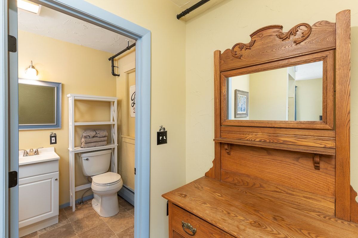 A small bathroom with a toilet, sink, and mirror.