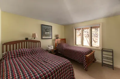 Cozy bedroom with two twin beds and a window overlooking the woods
