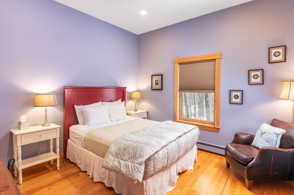 Cozy bedroom with a comfortable bed and a window overlooking the forest