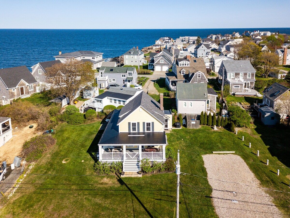 Aerial view of a beachfront house with a large yard and ocean views.