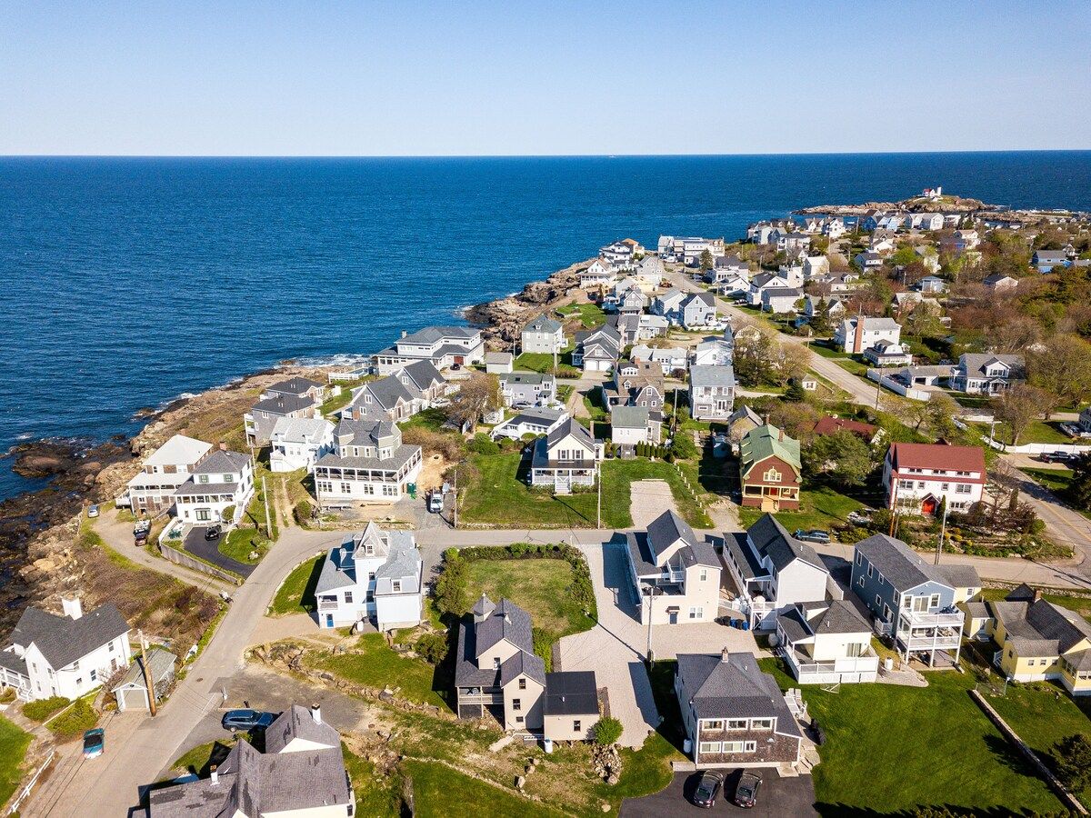 Aerial view of a coastal neighborhood with houses and ocean views on a sunny day