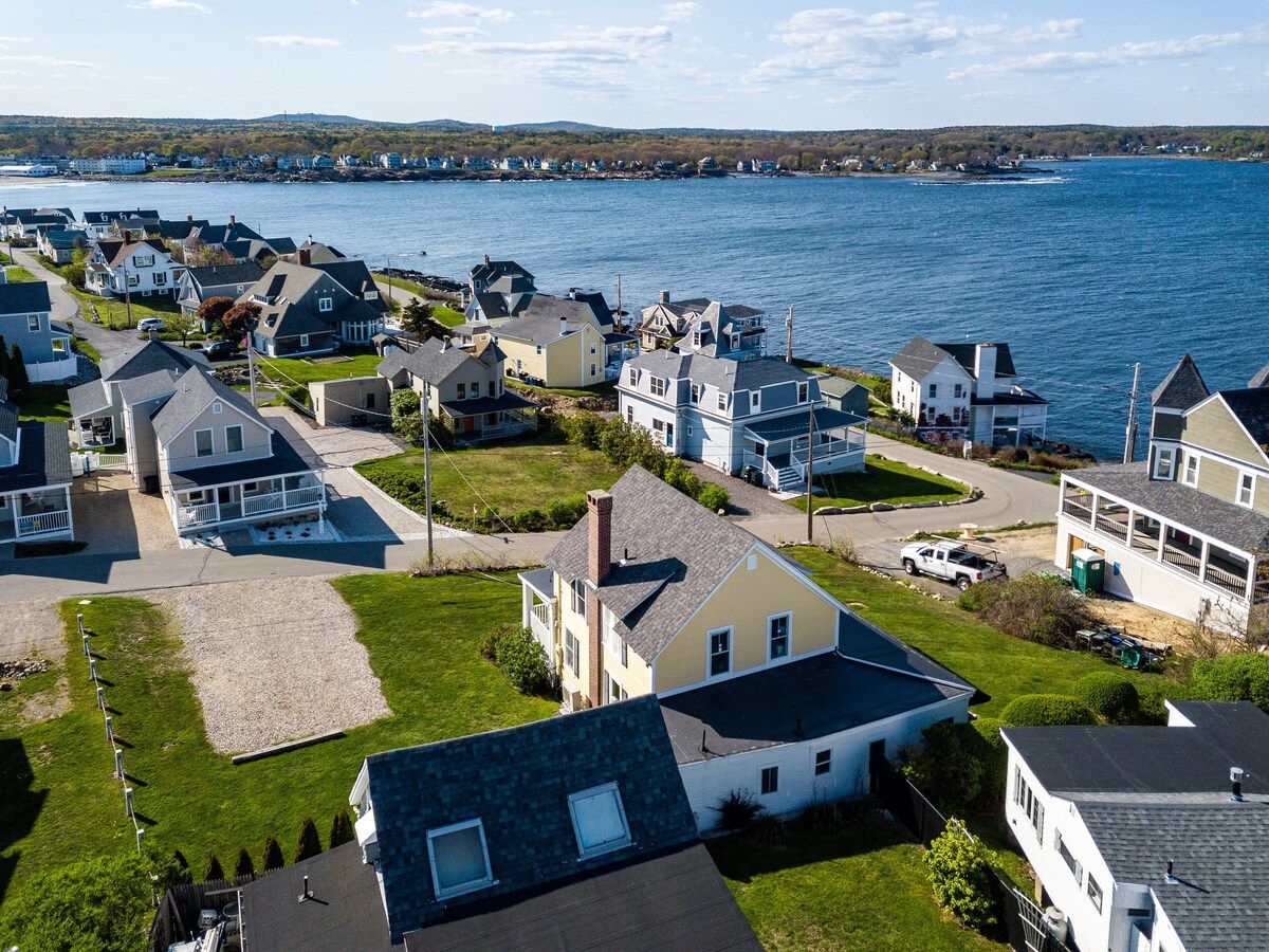 Aerial view of a coastal neighborhood with houses and a body of water.