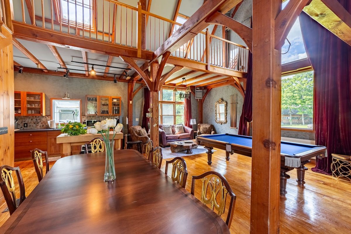 Spacious game room with a pool table and large windows overlooking the outdoors