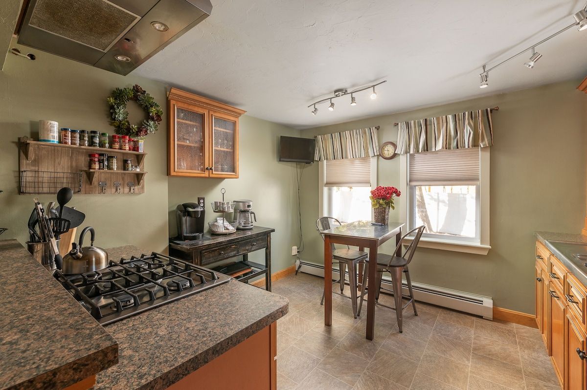 A well-equipped kitchen with granite countertops, a gas stove, and a breakfast bar.