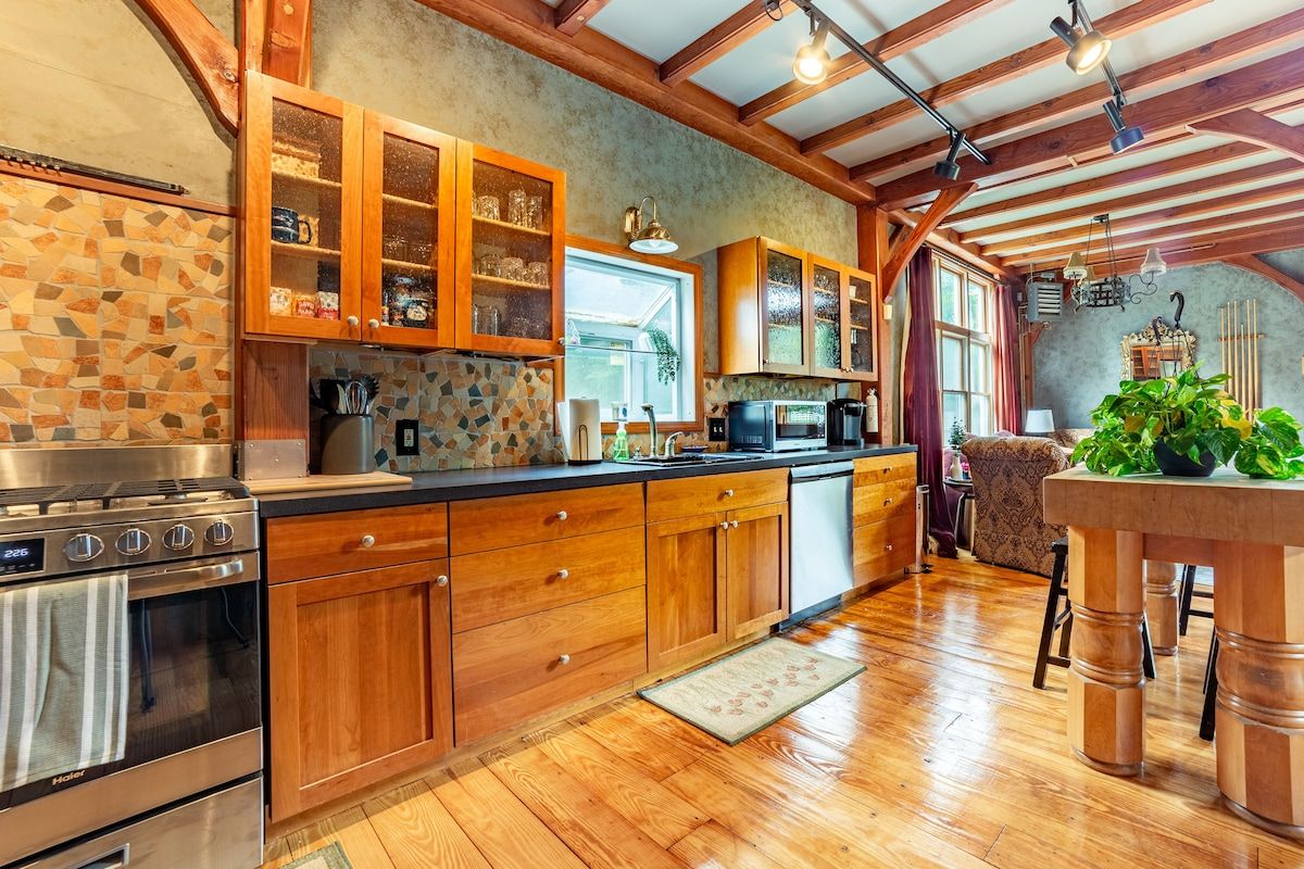 A well-equipped kitchen with stainless steel appliances and wooden cabinets, featuring a window above the sink.