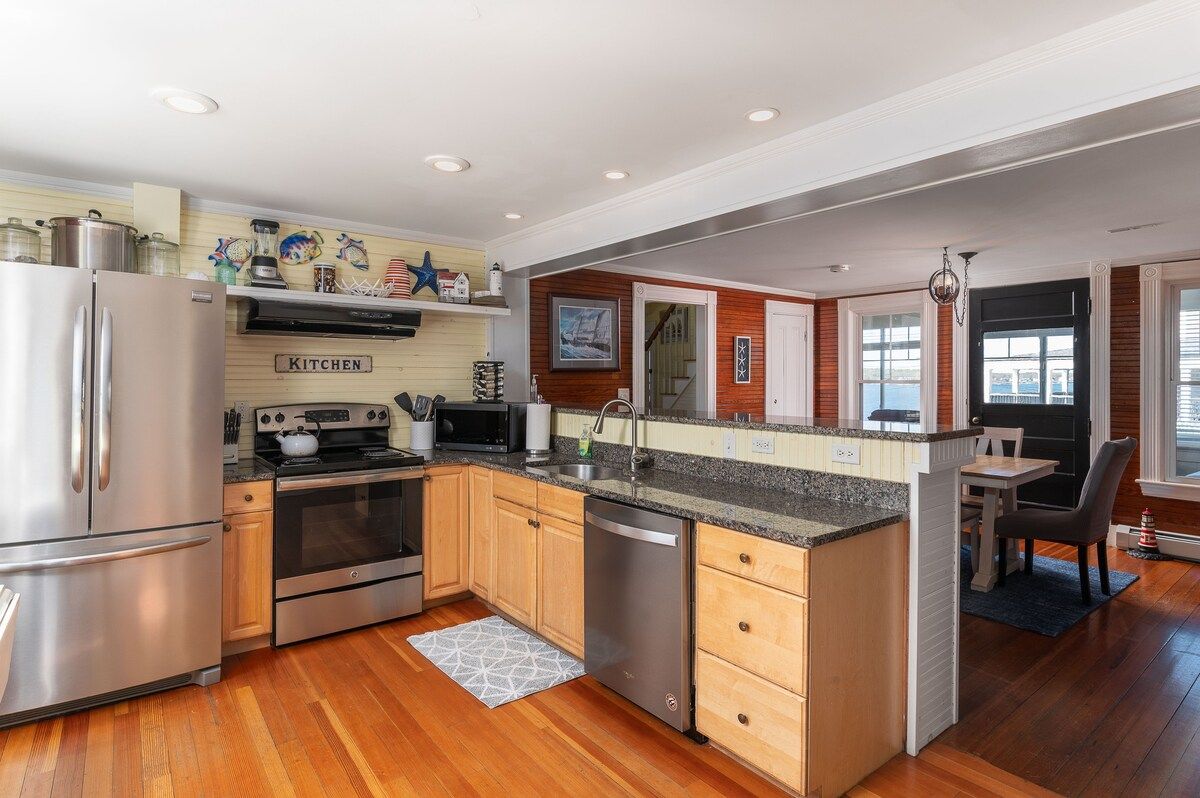 A well-equipped kitchen with stainless steel appliances and granite countertops, featuring a large island with a sink.