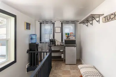 A compact kitchen with a water cooler, coffee maker, and mini fridge