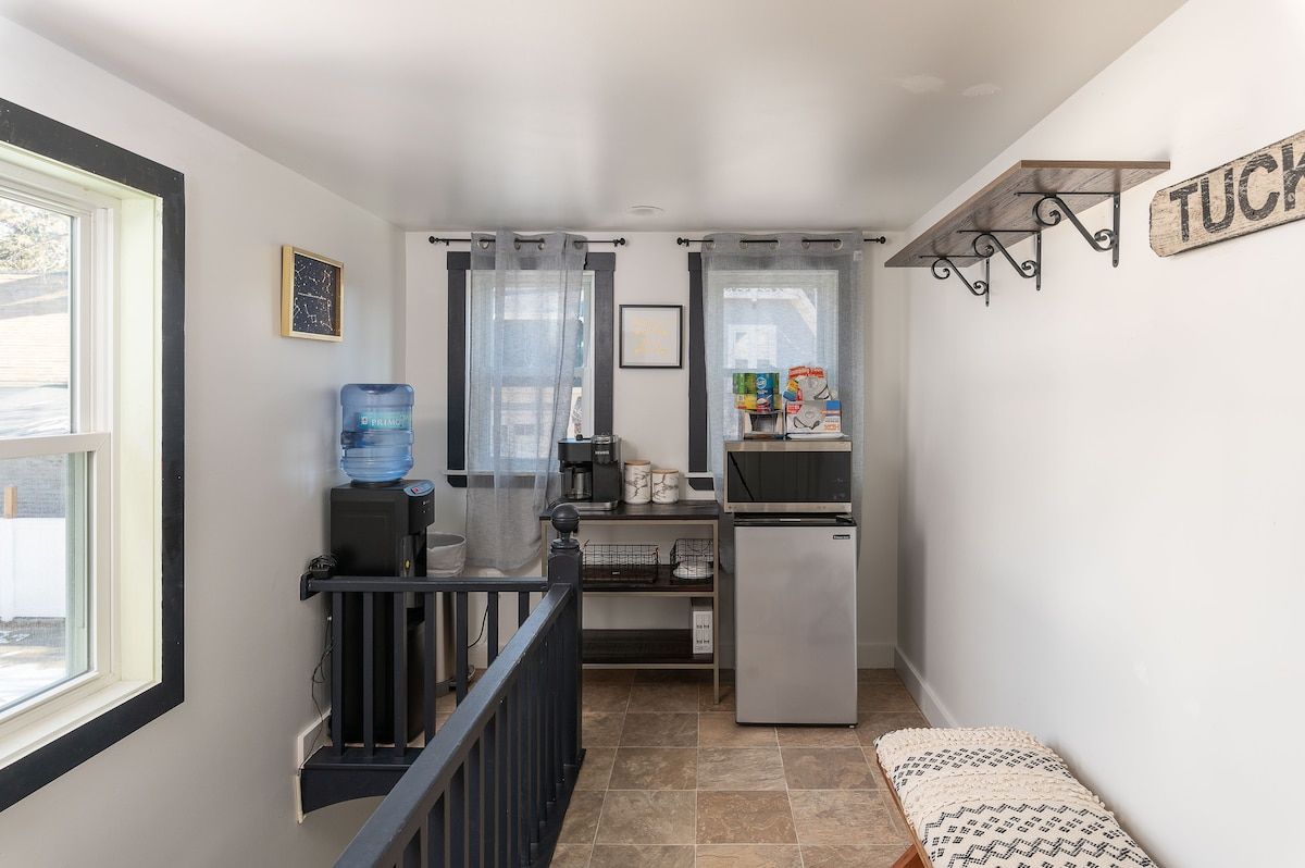 A compact kitchen with a water cooler, coffee maker, and mini fridge