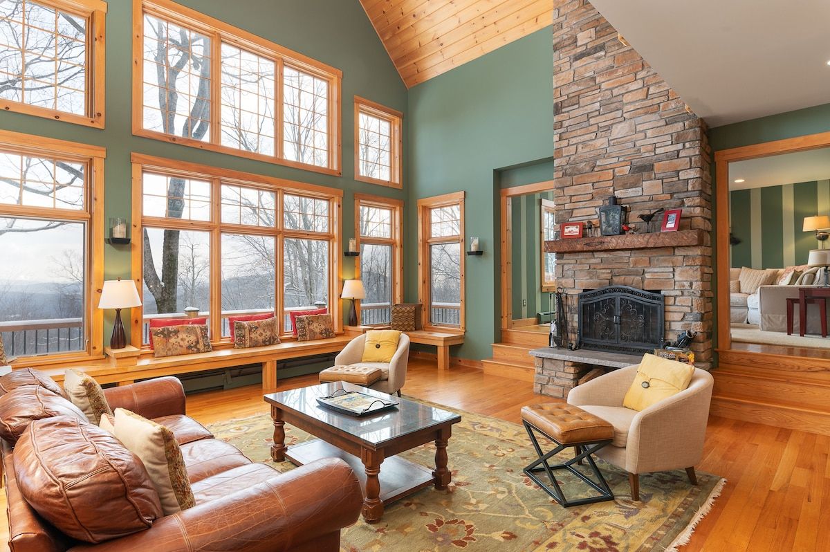 Cozy living room with a large stone fireplace and mountain views through the windows