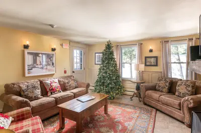 Cozy living room with Christmas tree and comfortable seating for a relaxing holiday stay