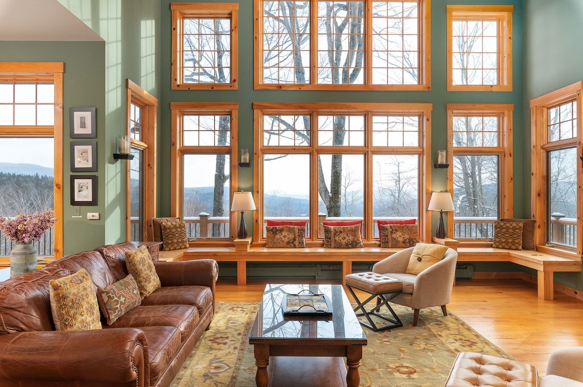 Cozy living room with leather sofa and large windows overlooking the mountains