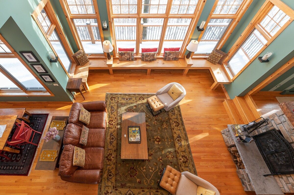 Cozy living room with large windows and a fireplace, perfect for relaxing after a day outdoors.