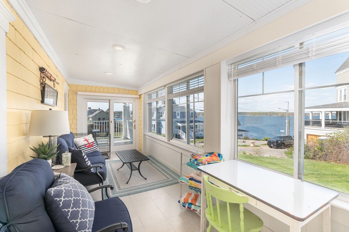 Cozy sunroom with comfortable seating and a beautiful view of the water