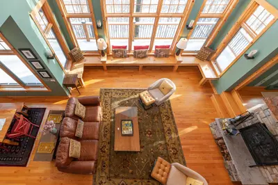 Cozy living room with large windows and a fireplace, perfect for relaxing after a day outdoors.