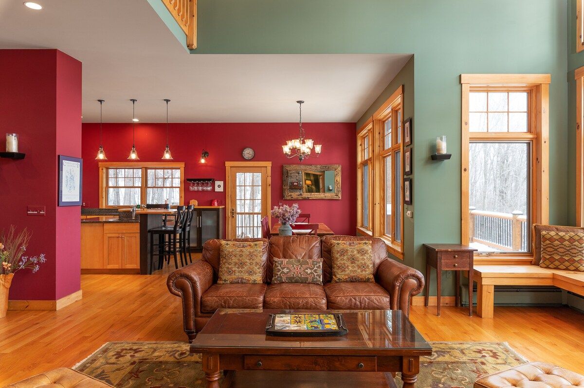A spacious living room with a brown leather couch and a coffee table in the middle.