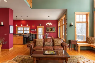 A spacious living room with a brown leather couch and a coffee table in the middle.