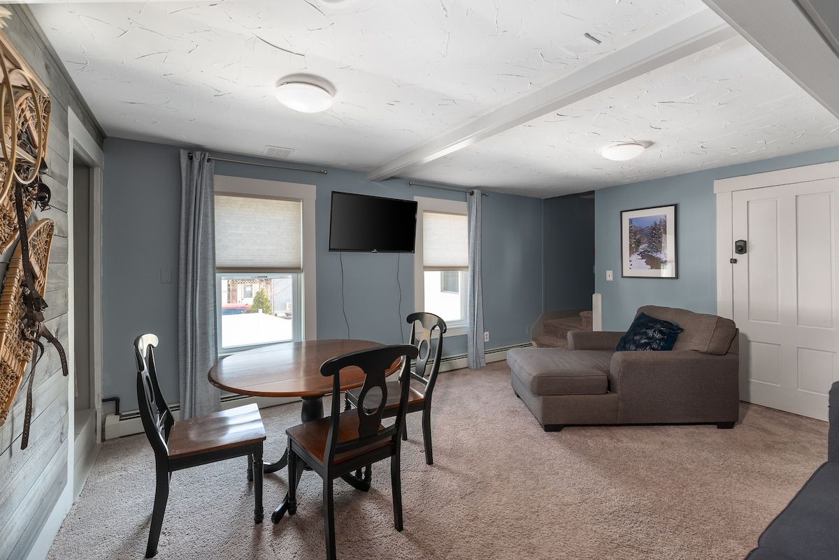 Cozy living room with comfortable couch and large TV on the wall.