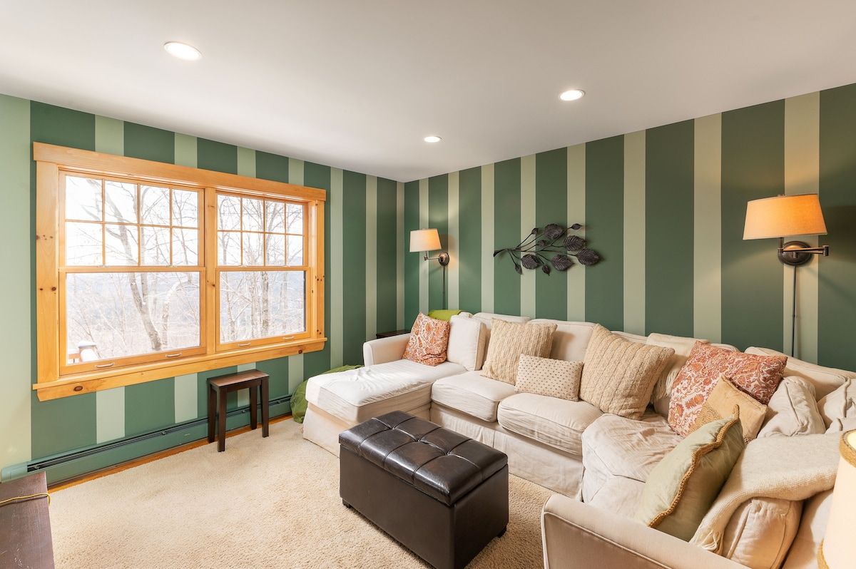Cozy living room with a sectional sofa and large window overlooking the winter landscape
