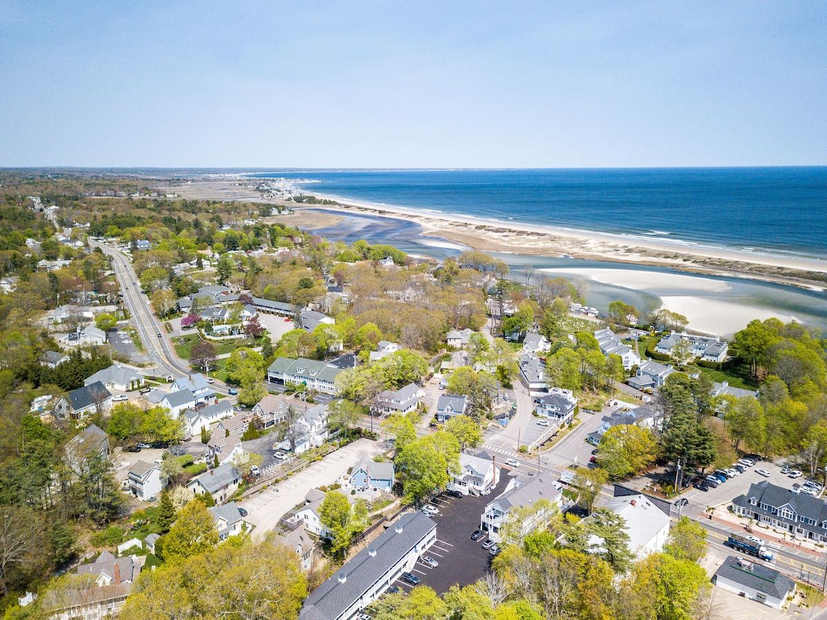 Aerial view of a coastal town with beach and ocean in the background.