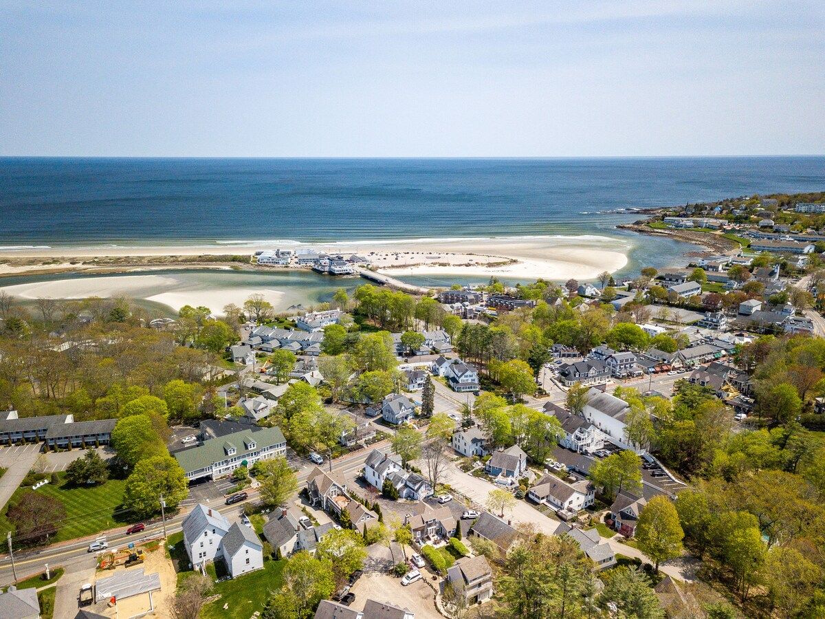 Aerial view of a coastal town with a beach and ocean in the background.