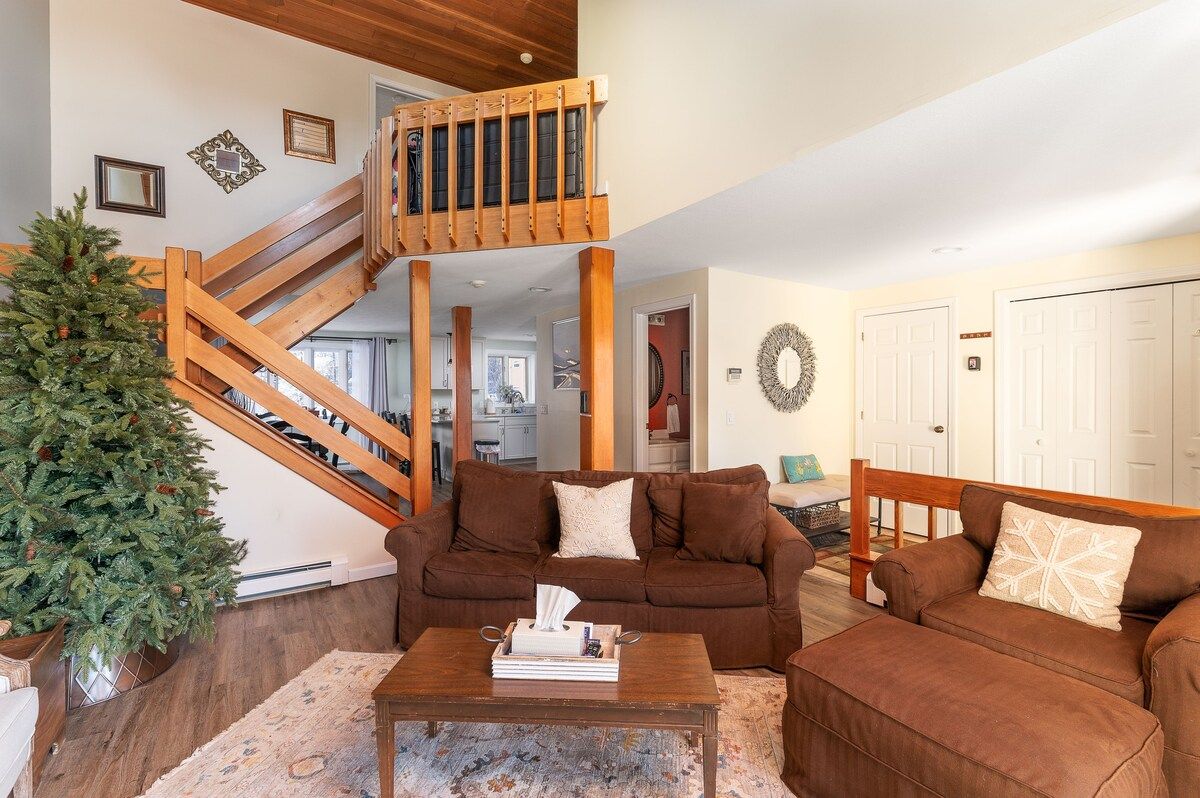 Cozy living room with brown couches and a Christmas tree
